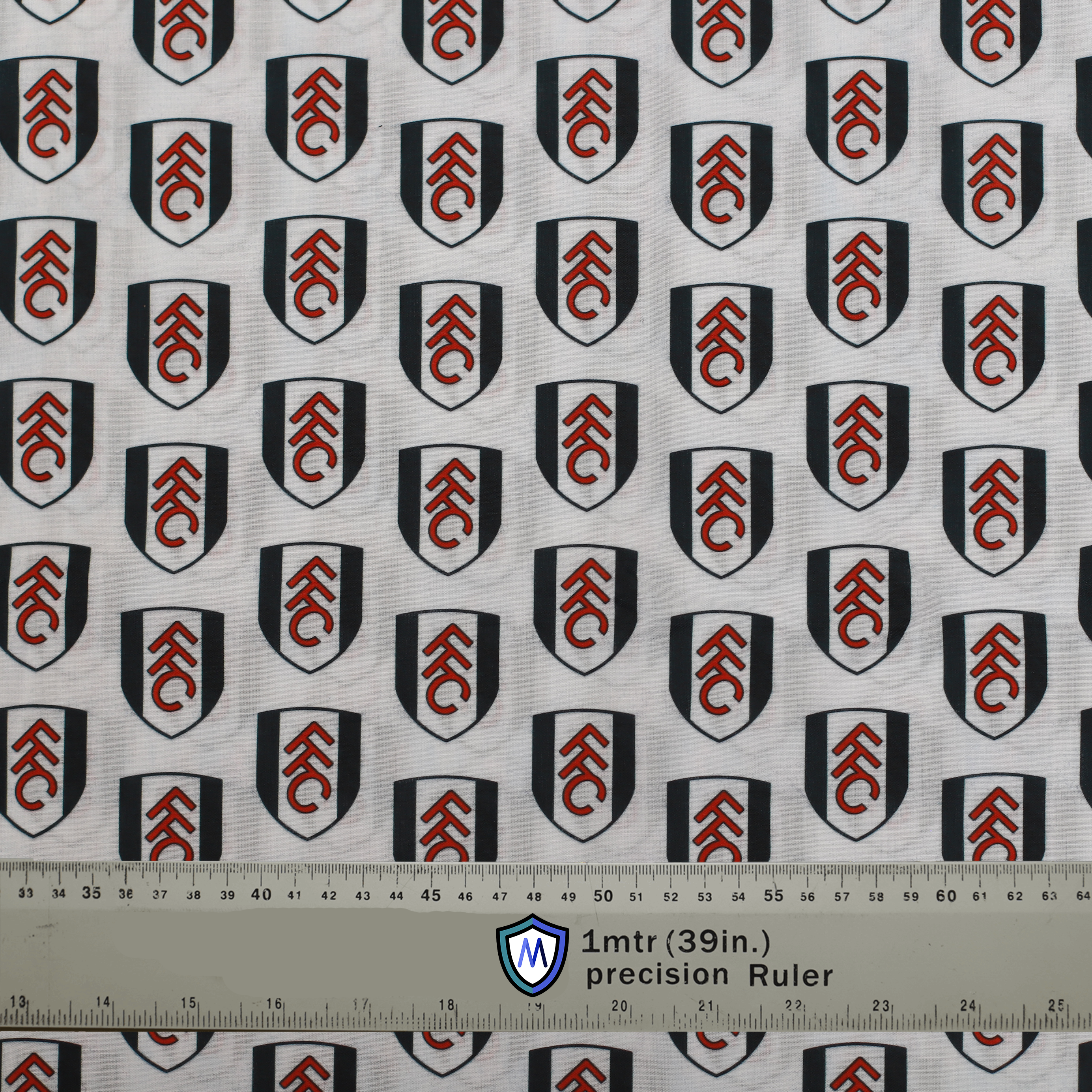 Fulham FC-themed Medicus Scrub Cap fabric with club crest pattern on a white background. Perfect for football fans in healthcare. Ruler for scale.