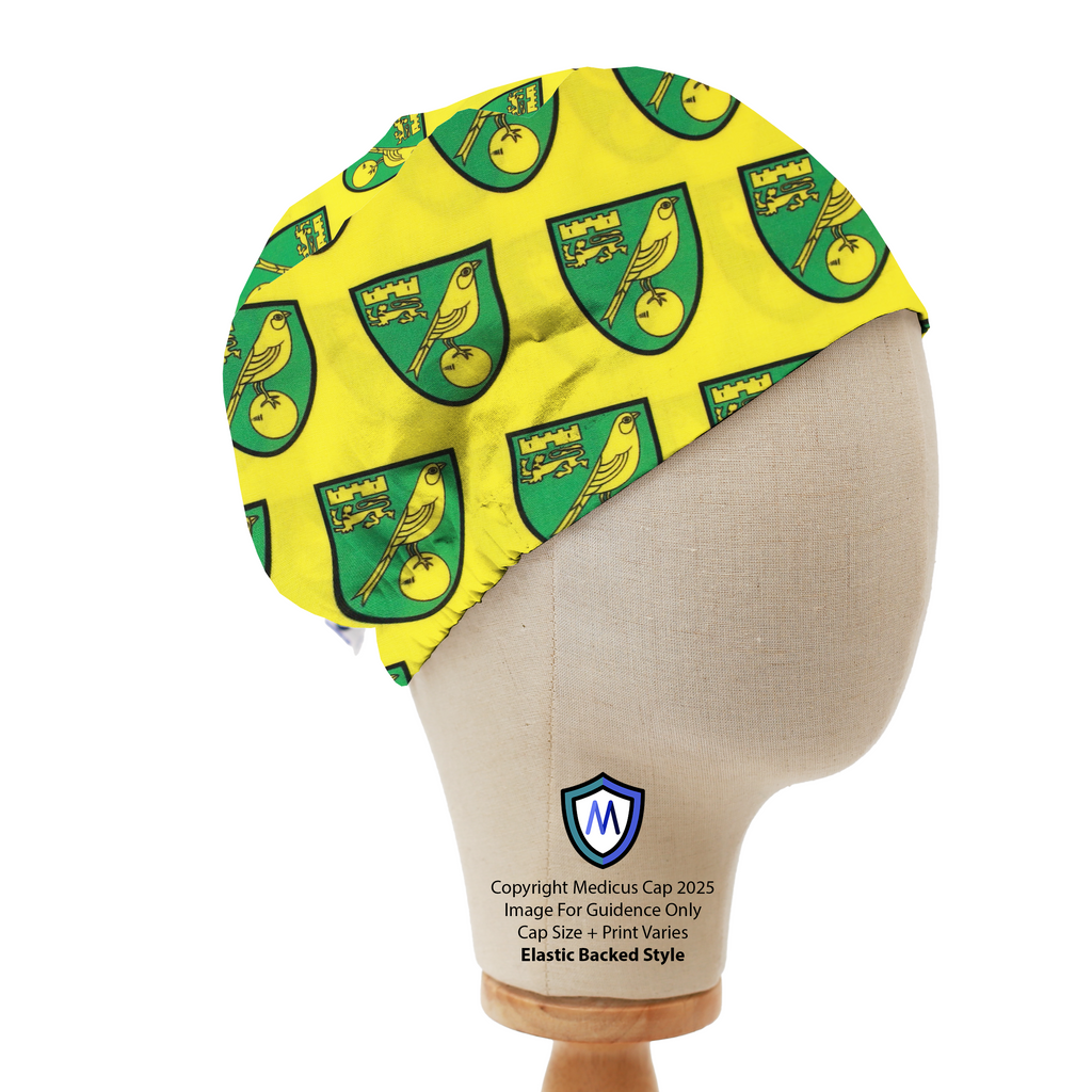 Mannequin head wearing a yellow Medicus Scrub Cap with repeated Norwich City FC crests in green and gold, elastic backed.