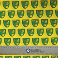 Fabric sample for Medicus Scrub Caps featuring Norwich City FC crests in green and gold on a yellow background, with a 1-meter ruler for scale.
