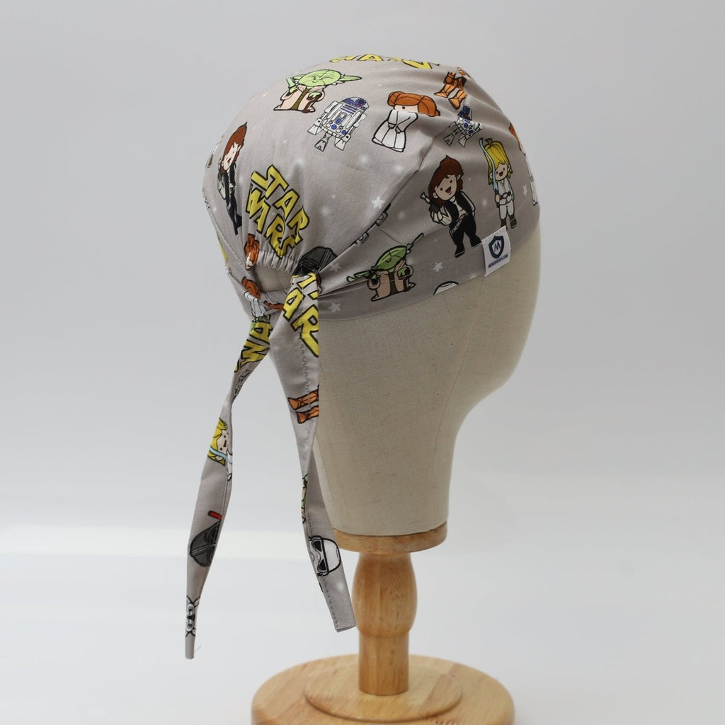 Custom grey scrub cap by Medicus Caps featuring cartoon galaxy heroes and robots print; back view with long tie straps.