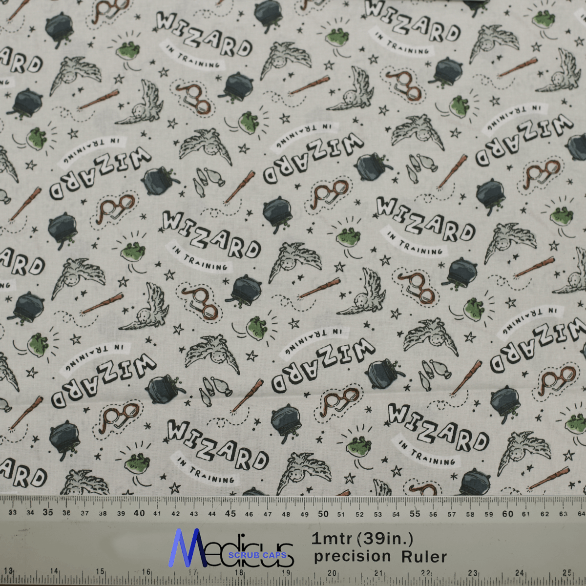 Close-up of Harry Potter Wizard In Training fabric for Medicus Scrub Caps, featuring wands, owls, cauldrons, and text, perfect for wizarding fans.