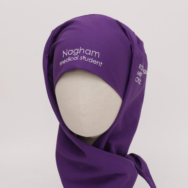 Purple hijab with 'Nagham medical student' text on a mannequin head against a white background