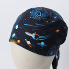 Back view of black scrub cap with colorful space pattern featuring planets, rockets and blue orbital designs
