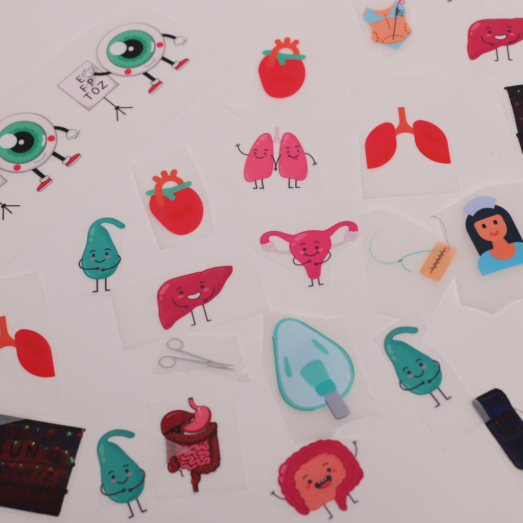 Collection of colourful iron-on DTF vinyl transfer designs featuring cartoon medical organs including hearts lungs liver and stomach by Medicus Caps