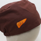 Brown scrub cap with orange carrot character vinyl transfer design, close-up detail view