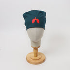 Teal scrub cap with red lung graphic design displayed on mannequin head front view