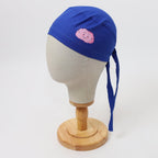 Blue scrub cap with pink smiling brain design shown on mannequin head side view