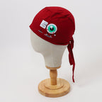 Red scrub cap with eyeball and text patches shown on mannequin head side view