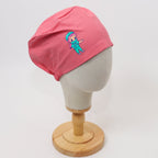 Pink scrub cap with cute cartoon surgeon character design shown on mannequin head side view