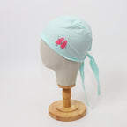 Light mint green scrub cap with pink lungs design shown on mannequin head side view