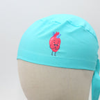 Close-up of turquoise scrub cap featuring cute pink heart character with face and legs