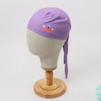 Purple scrub cap with dental implant vinyl design shown on mannequin head side view