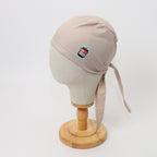 Beige scrub cap with B positive blood pack vinyl design shown on mannequin head side view