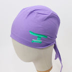 Purple scrub cap with green operating table vinyl design shown on mannequin head side view