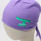Purple scrub cap with green Gemini zodiac symbol vinyl transfer, side profile view