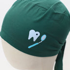 Green scrub cap close-up showing white tooth and blue dental mirror vinyl design detail