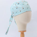 Side view of light blue scrub cap with colorful surfer pattern on mannequin head