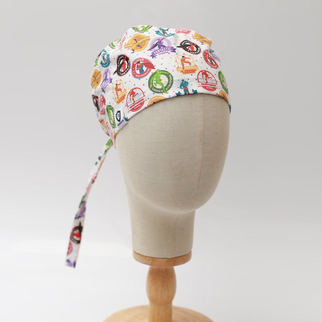 Medicus Scrub Cap with colorful superhero-themed design for anaesthetists, displayed on a mannequin. "Anaesthetist Superheroes" pattern celebrates medical professionals.
