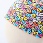 Love Drug Candy scrub cap fabric pattern close-up