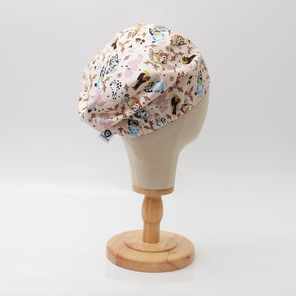 Medicus Scrub Cap featuring a Bluey-themed family and friends pattern on a beige background, displayed on a mannequin head.