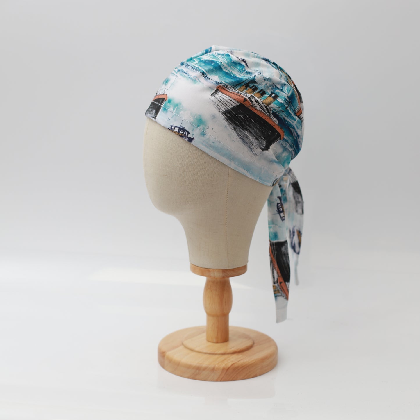 Grey’s Anatomy-inspired Medicus scrub cap with a ferry boat pattern, displayed on a mannequin head. Blue and white tones evoke a nautical theme.