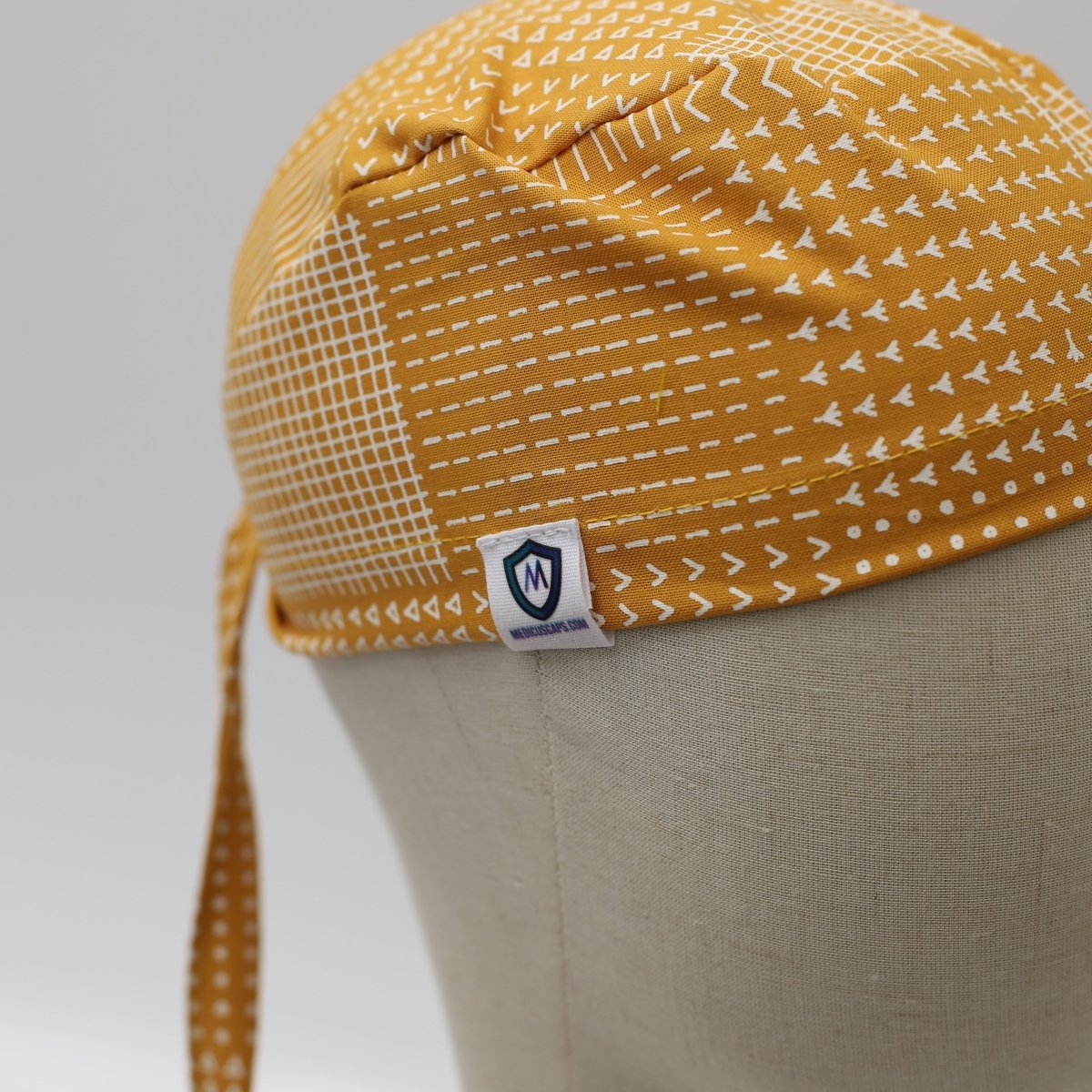 Líneas abstractas sobre gorro quirúrgico color mostaza