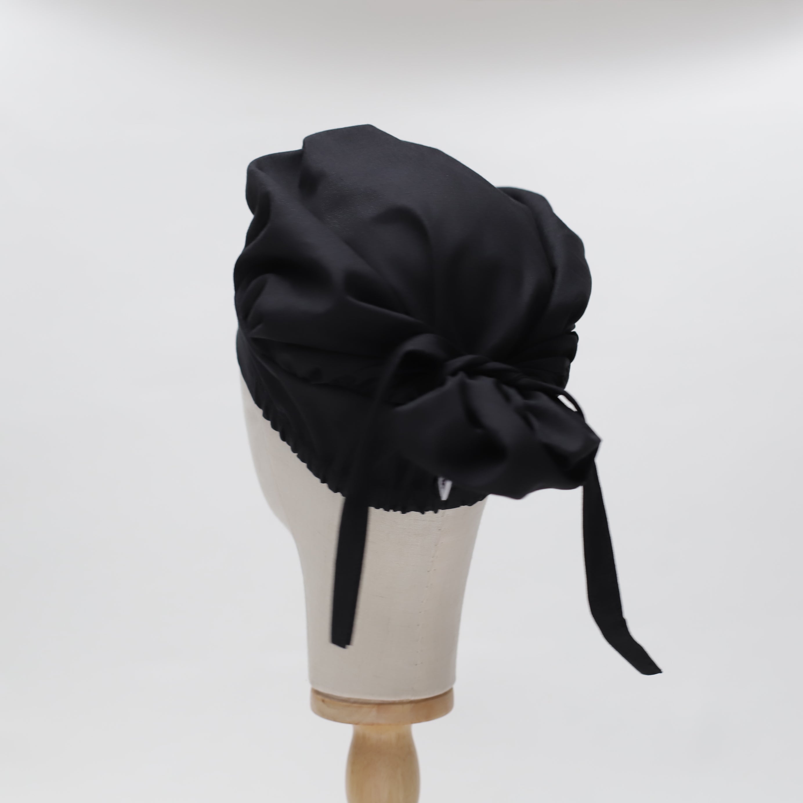 Black bouffant scrub cap by Medicus Scrub Caps, reusable and adjustable with a tie-back design. Stylish and functional for medical professionals.