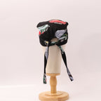 Back view of vintage cars motorsport scrub cap showing black fabric with colorful car prints and tie strings