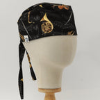 Black scrub cap with golden musical instruments pattern shown on mannequin head side view