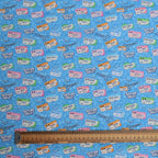 Patterned fabric with medical labels and tools on a blue background, ruler for scale.