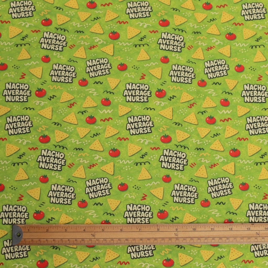 Fabric with 'Nacho Average Nurse' text and graphics on a green background, ruler at the bottom.