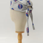 Close-up side view of gray scrub cap with blue NASA logo circles and red accents showing tie detail