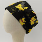 Side view of Pokemon Pikachu scrub cap showing yellow characters and Pokeball designs on black fabric