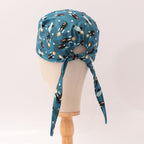Back view of blue scrub cap with rocket and spaceship pattern showing tie strings