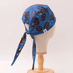 Back view of blue scrub cap with black motorcycle pattern showing tie details