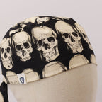 Close-up detail of skull pattern scrub cap showing cream colored skulls on dark background