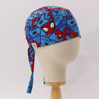 Side profile view of Spiderman comic web grid scrub cap with blue background and red superhero faces