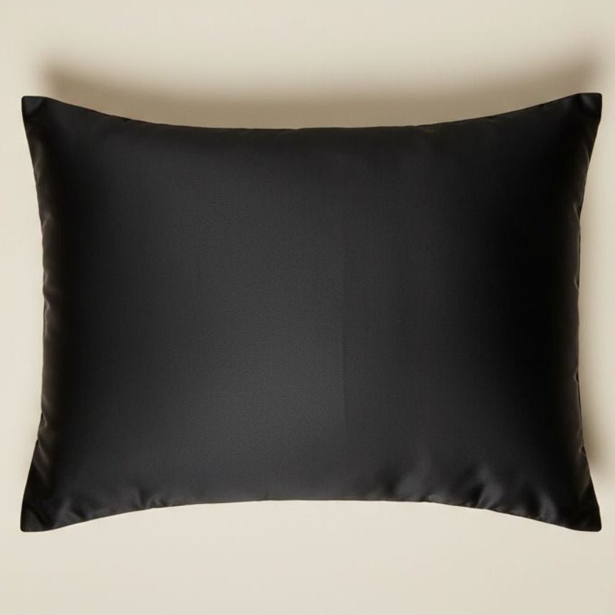 Black satin pillowcase displayed on a beige background, smooth luxurious fabric product photo