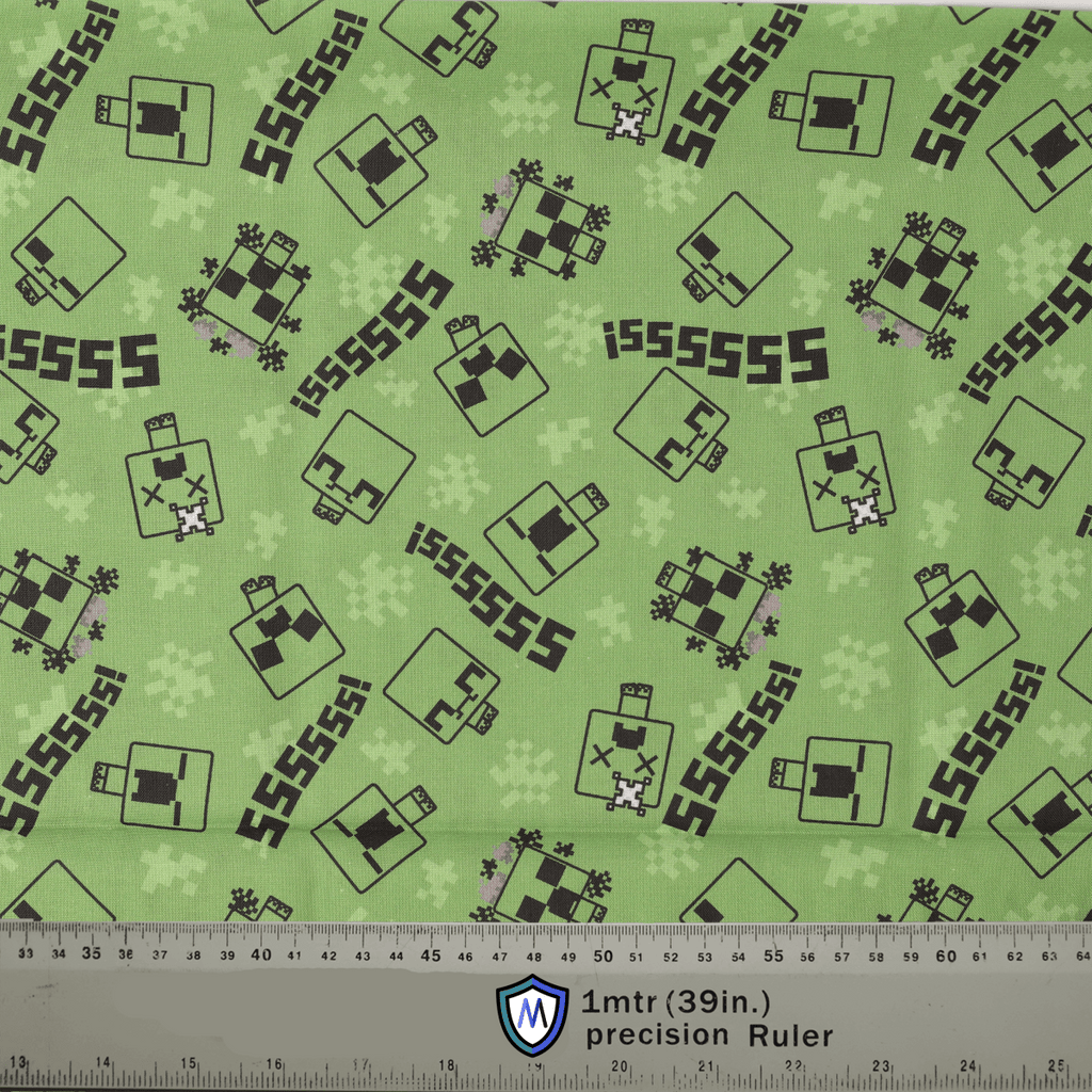 Green fabric with black and white pattern and ruler at the bottom