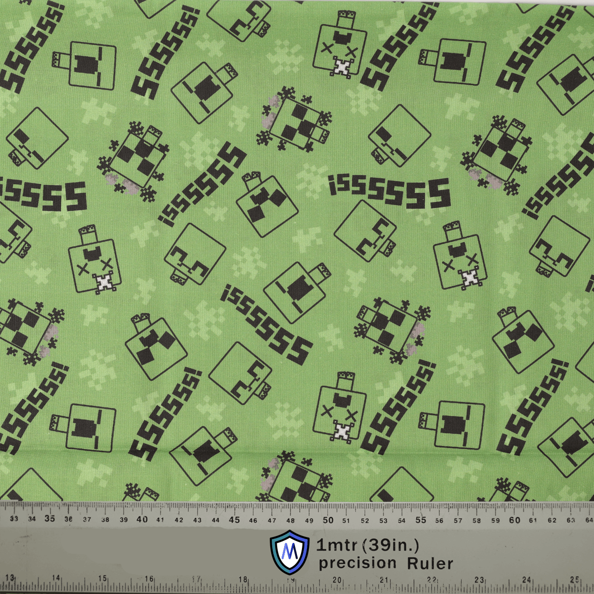 Green fabric with black and white pattern and ruler at the bottom