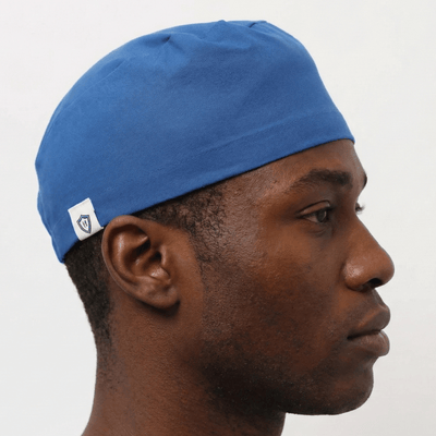 Person wearing a blue cap with a white logo on a gray background