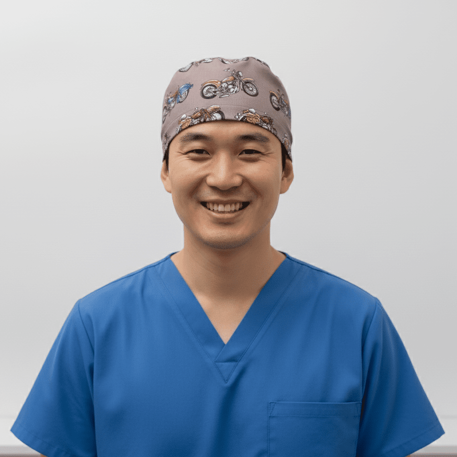 Grey scrub cap with vintage motorcycle pattern shown on smiling healthcare professional front view