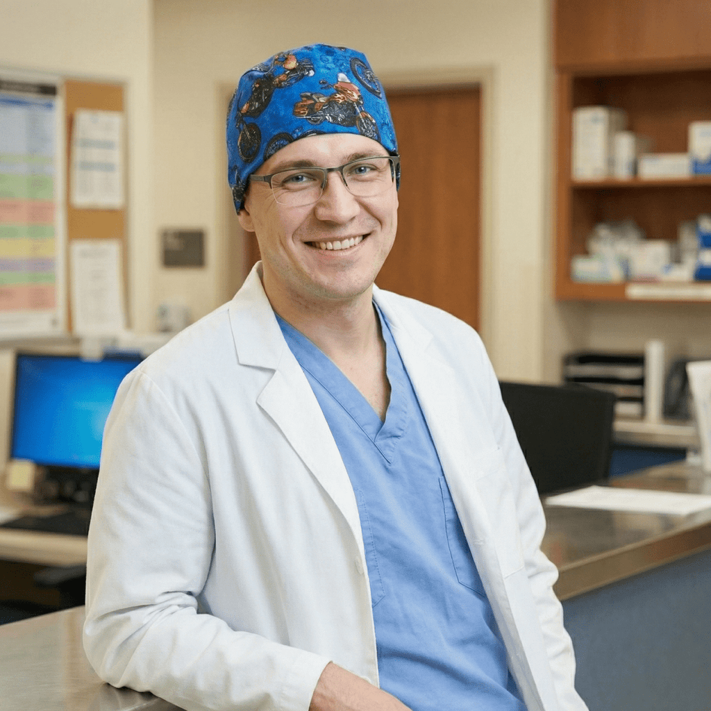 Healthcare professional wearing dark blue scrub cap with colorful motorcycle pattern, front view in medical office
