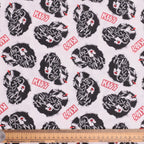 Close-up view of Kiss band scrub cap fabric showing black face designs and red logos on white background
