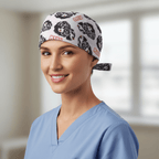 White scrub cap with black skull pattern and red text, tie-back style