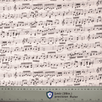 Close-up detail of musical notation pattern on off-white fabric scrub cap with ruler for scale