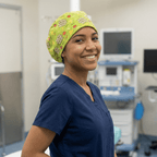 Healthcare worker wearing bright green avocado pattern scrub cap with nacho text, side profile view