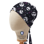 Side profile view of black scrub cap featuring white skull faces with purple moon and star accents