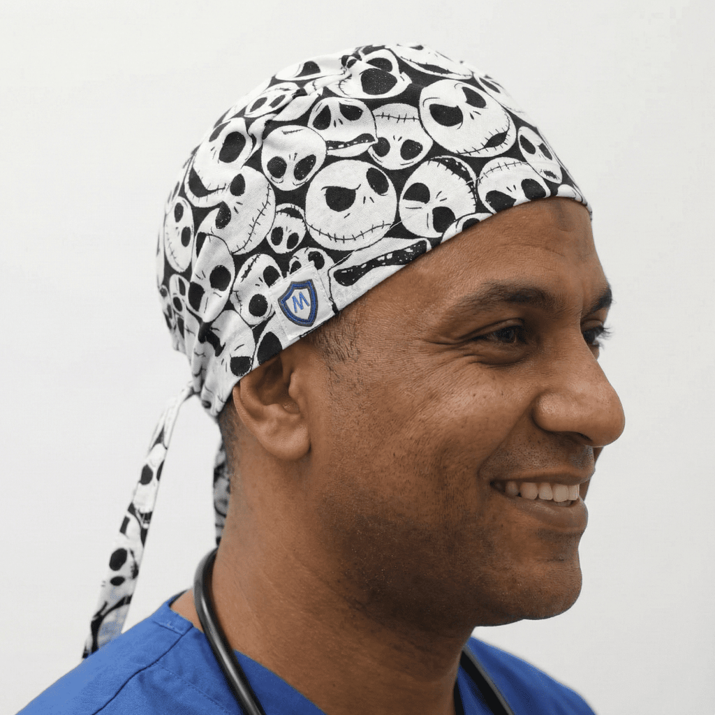 Black and white skull pattern scrub cap with tie-back closure worn by healthcare professional
