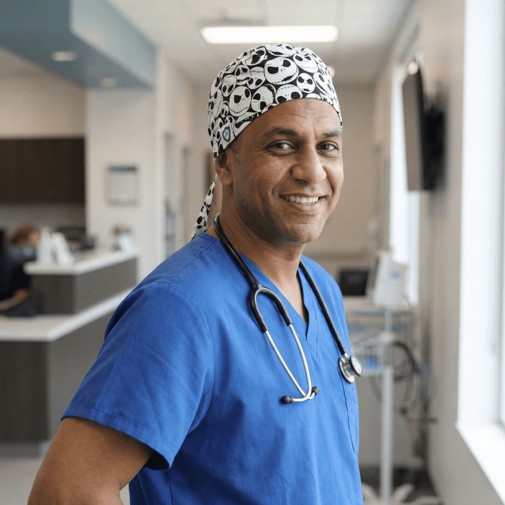 Medical professional wearing Nightmare Before Christmas skulls on white scrub cap, side profile view